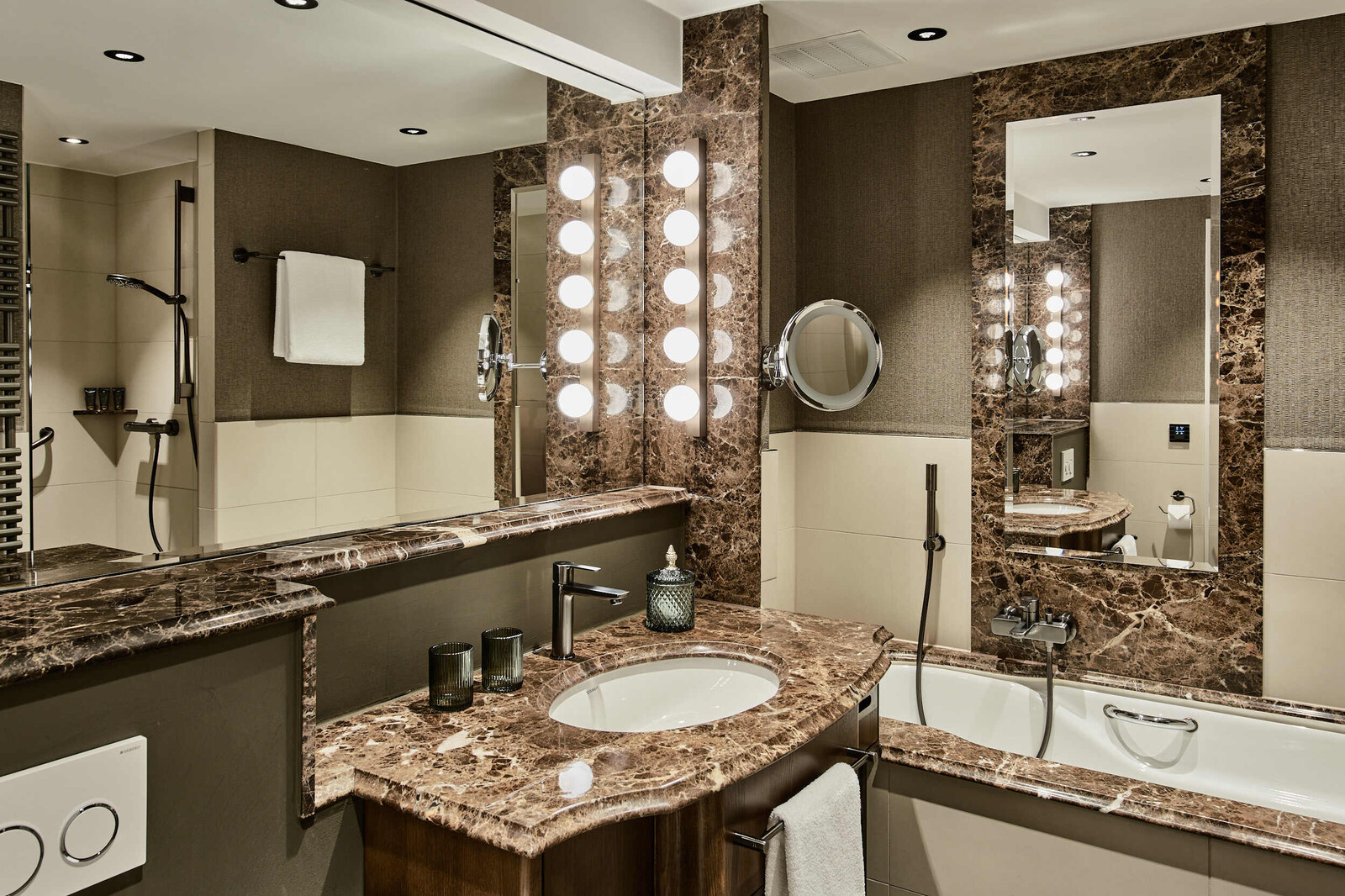 Blick ins Marmorbadezimmer eines Comfort Zimmers im Grand Hotel Hof Ragaz auf die Badewanne und den Waschtisch.