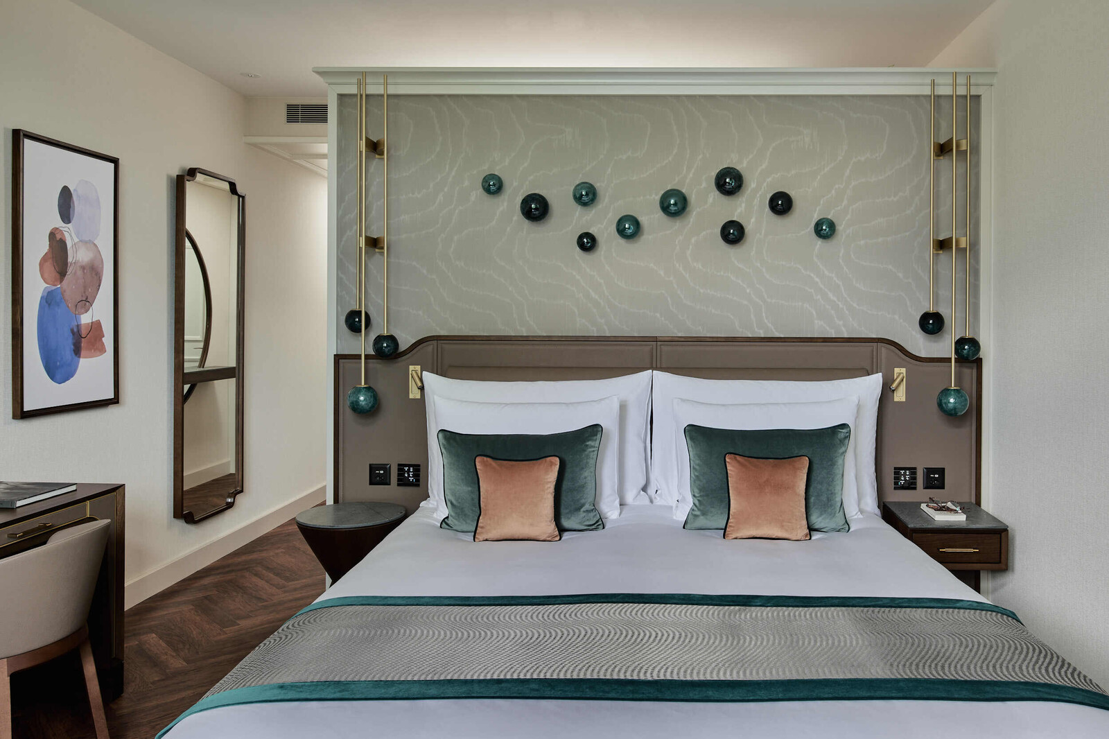 View of the bed in a comfort room at the Grand Hotel Hof Ragaz. Dark wood, blue, and purposefully placed earth tones create a soothing atmosphere.