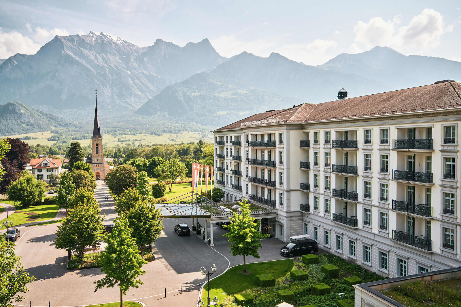 Blick vom Balkon eines Comfort Zimmers im Grand Hotel Hof Ragaz. Zu sehen ist die atemberaubende Bergkulisse der Büdner Herrschaft und das Grand Hotel Quellenhof im Vordergrund.