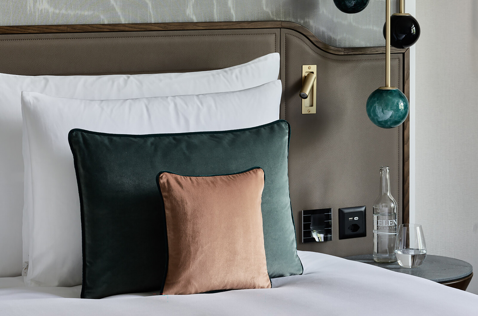 Detail of the right side of a double bed in Grand Hotel Hof Ragaz. Brown, white and gray together with blue and orange create harmony.