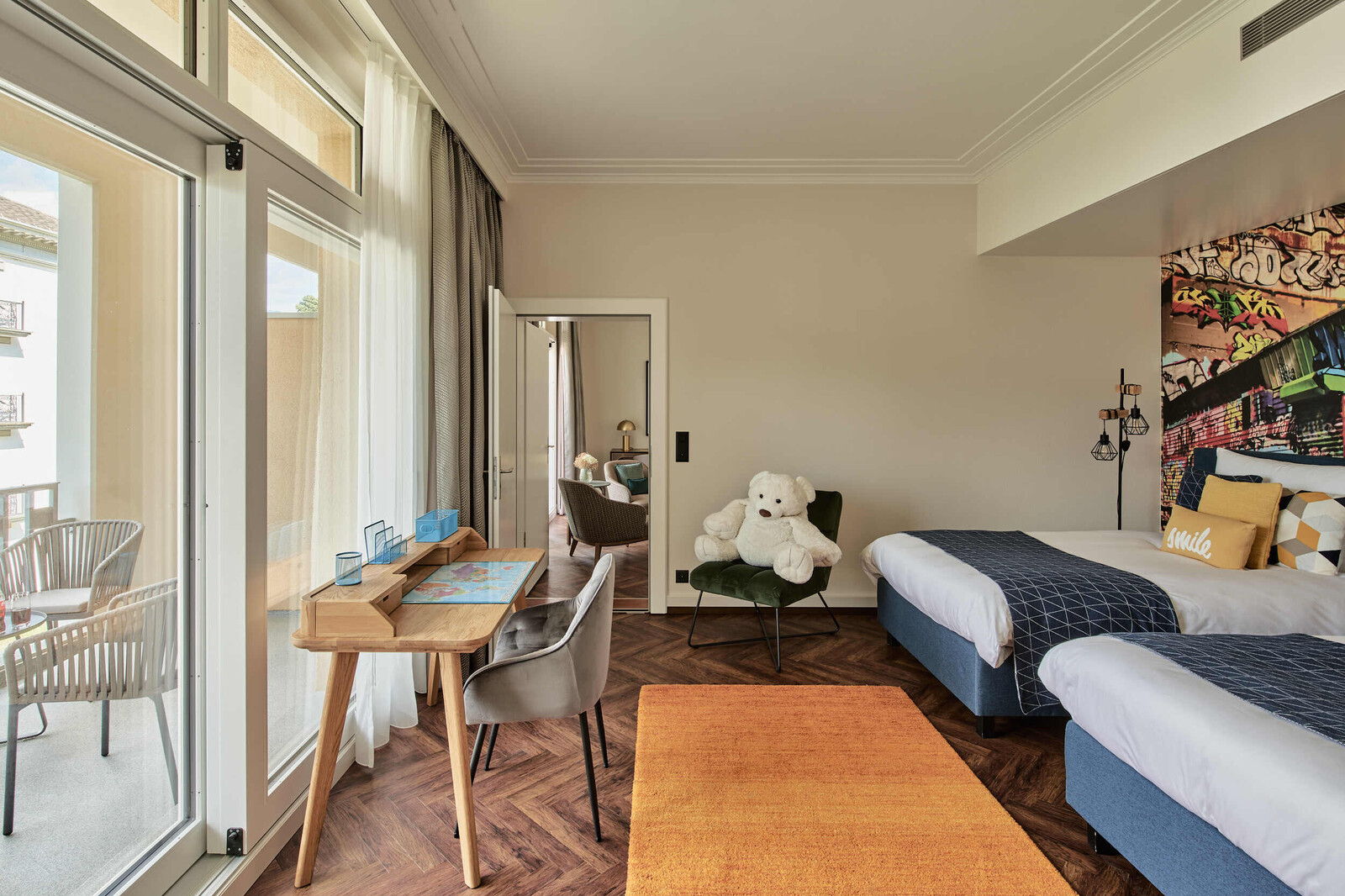 Kinderzimmer mit zwei Betten und einem Schreibtisch, des Familienzimmers des Grand Resort Bad Ragaz.