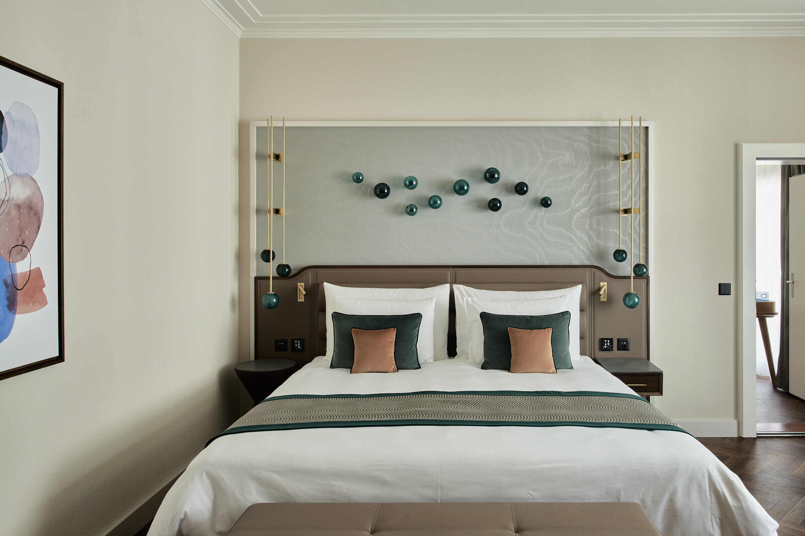 Blick frontal auf das Bett der Eltern des Familienzimmers. An der Wand des Bettes sind kugelförmige blaue Glaselemente angebracht.