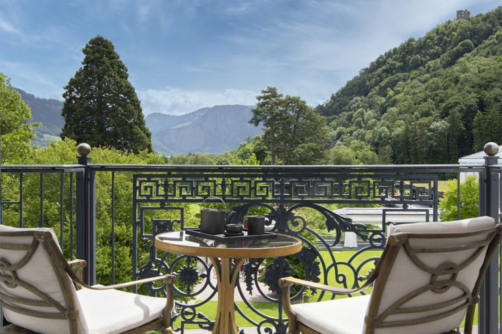 Elegant bedroom with a tall, cushioned beige headboard, white pillows, and gold-accented cushions.