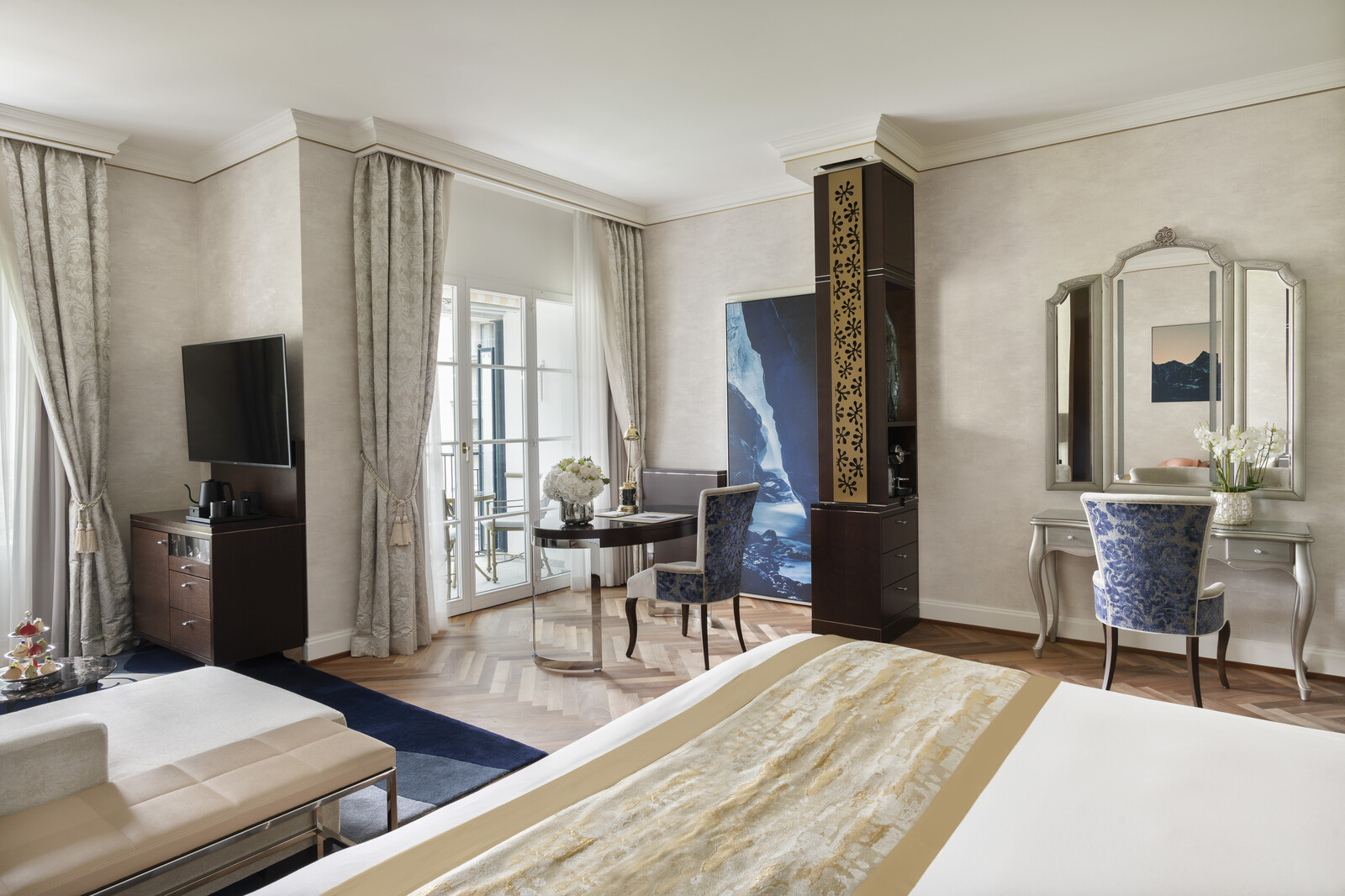 Luxuriöses Hotelzimmer mit einem Plüschbett, goldenen Akzenten, bunten Kissen und eleganter Beleuchtung, die eine warme, einladende Atmosphäre schaffen.