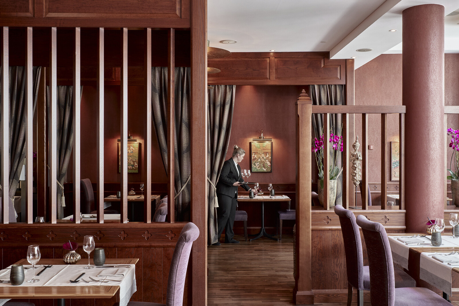 Die Sommelière verteilt Gläser auf den Tischen des Restaurants.