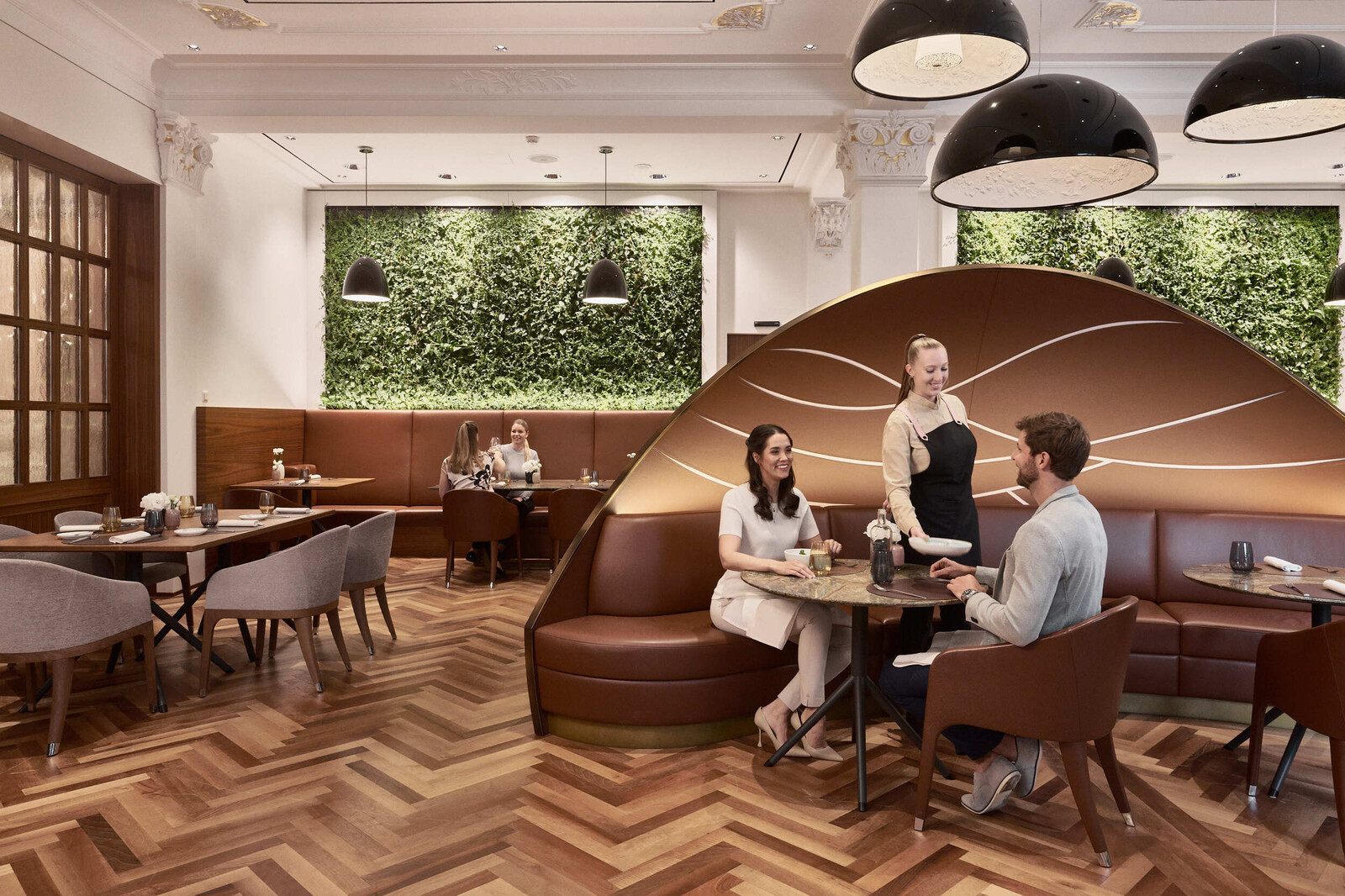 Eine Kellnerin serviert einem Paar Speisen im Restaurant Verve.