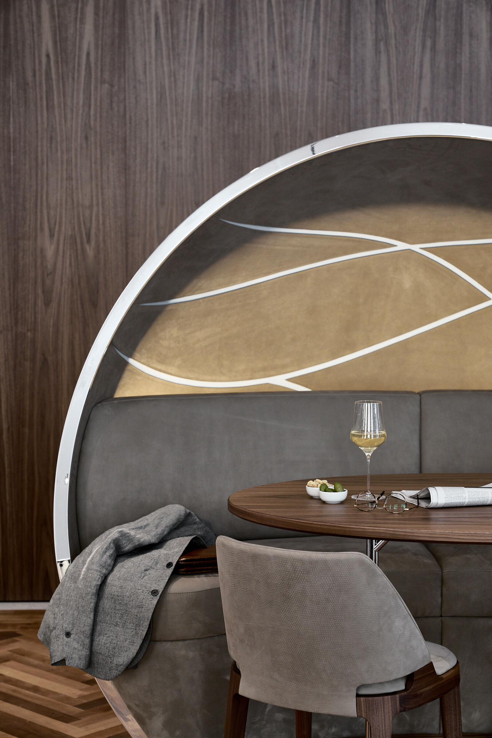 Eine Sitzecke im Restaurant verve by sven mit einem Glas Weißwein auf dem Tisch.