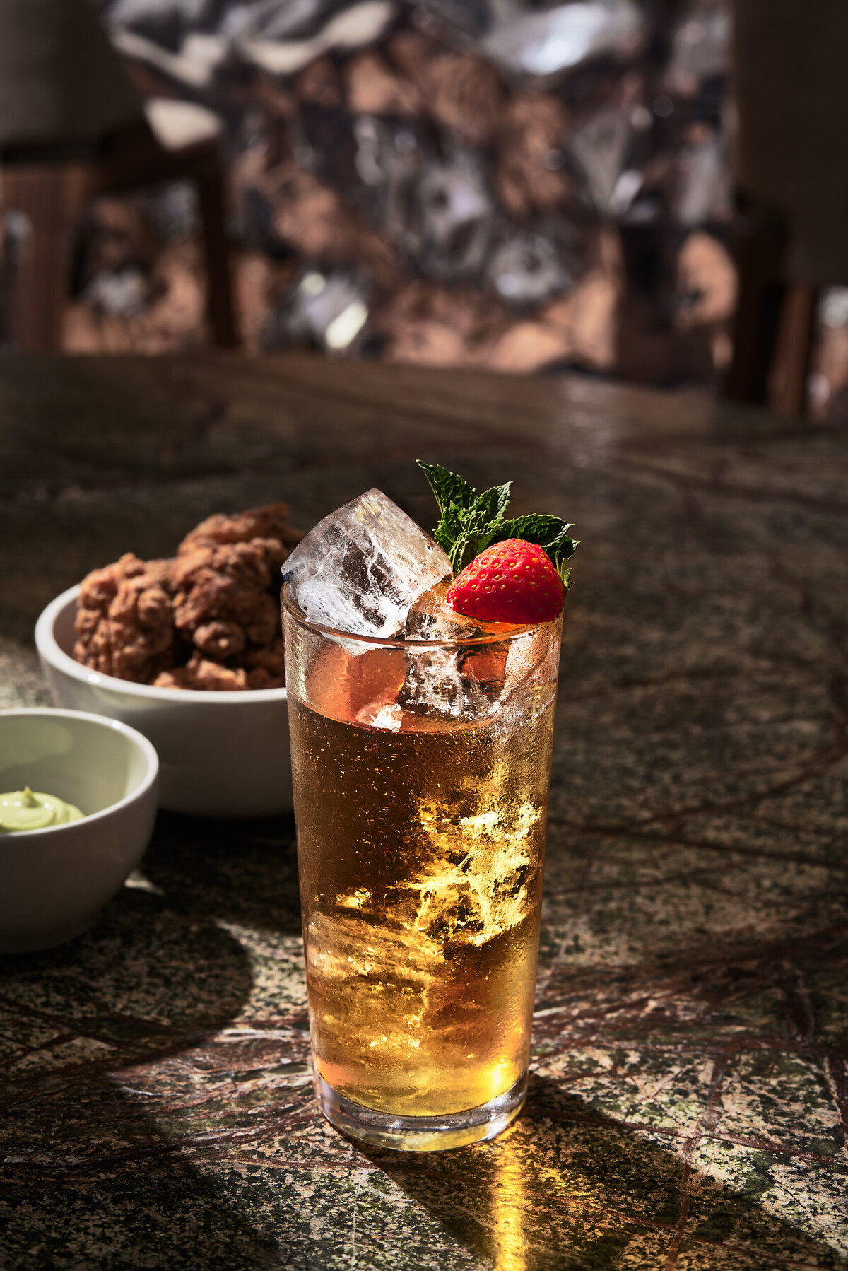 Ein hausgemachter Hemp Ice Tea serviert mit Eis und Erdbeere im verve by Sven.