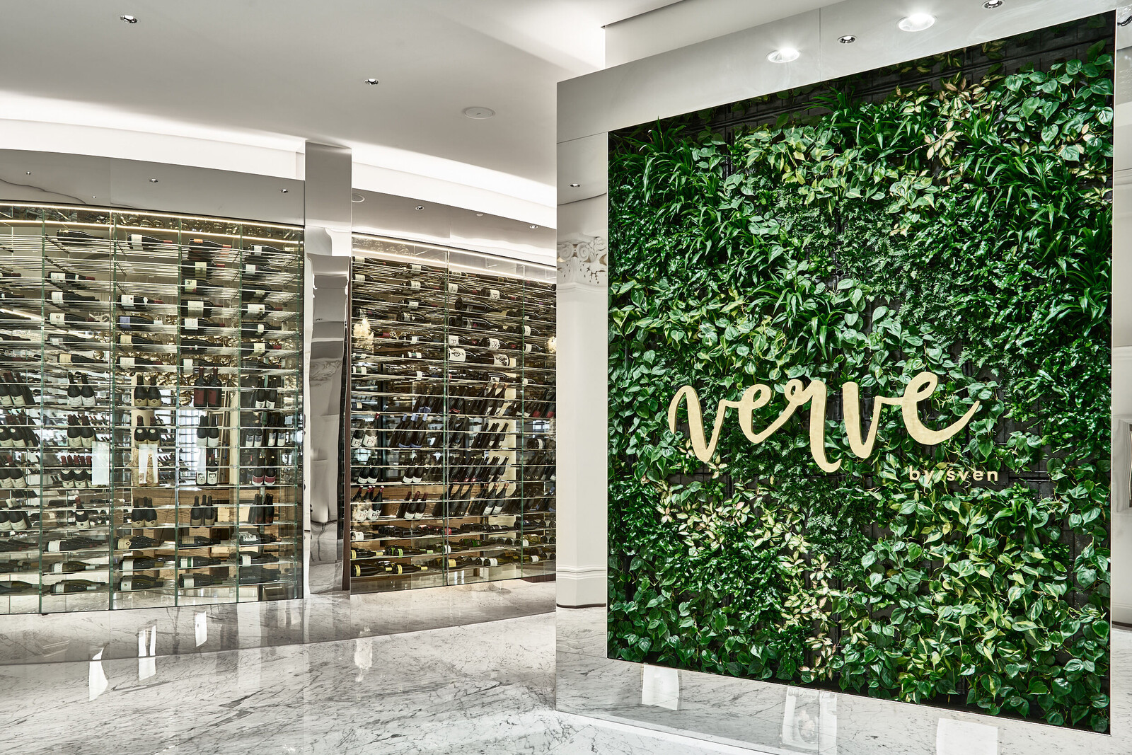 Das Logo des Restaurants verve by sven an einer mit Grünpflanzen bewachsenen Wand neben dem Weinlager.