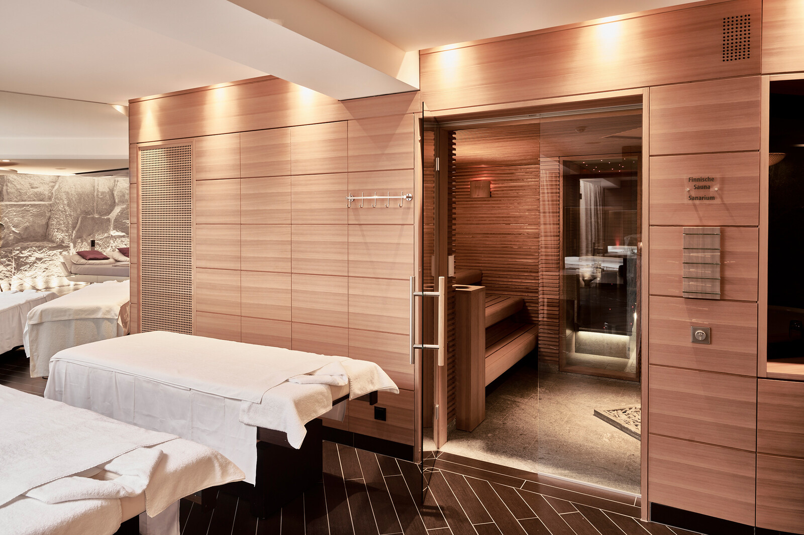 Blick in modernen Private Spa mit finnischer Sauna und Massageliegen.