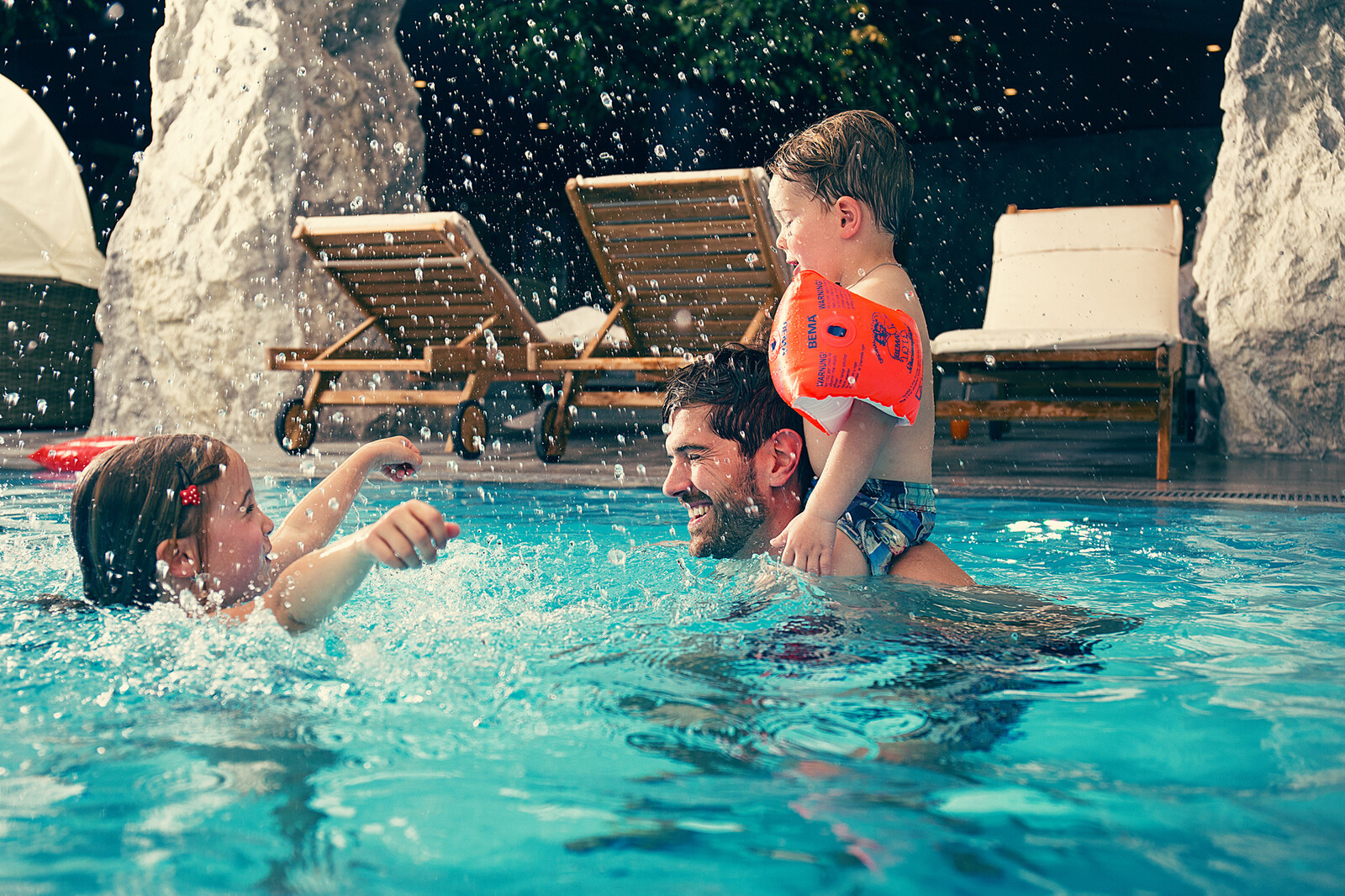 A father splashes around with his two children at the Family Spa.