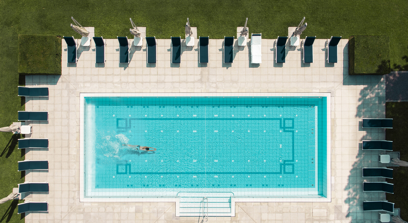 A shot from above the Garden Pool at the Grand Resort Bad Ragaz while a woman jumps into the pool.