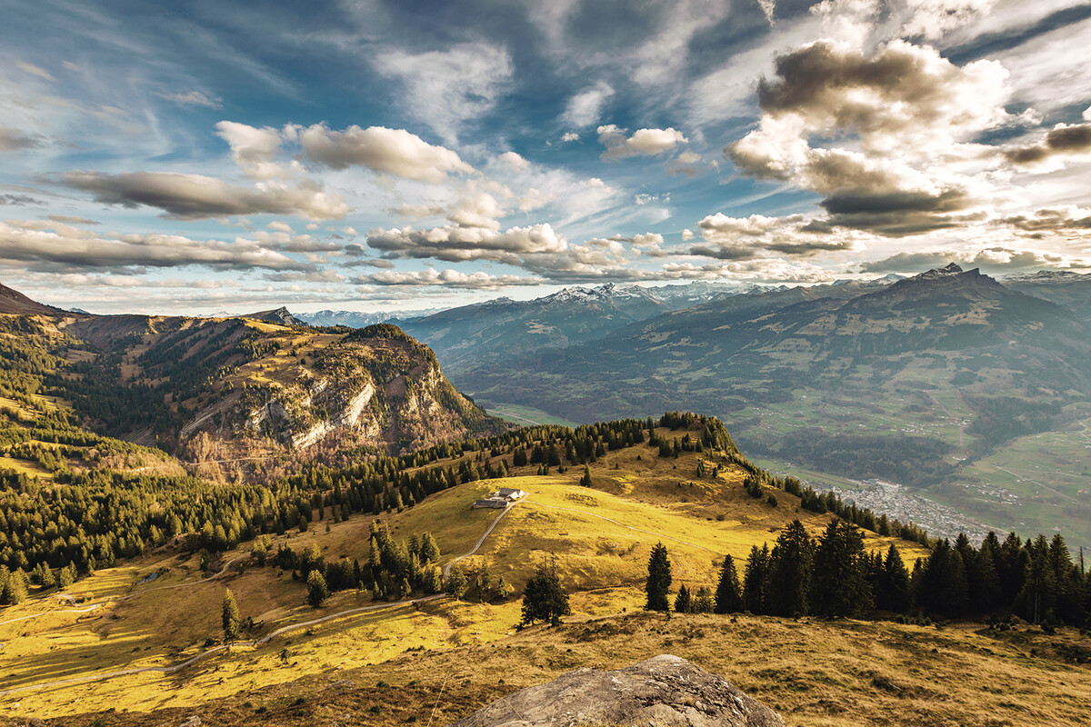 Alpenpanorama mit grüner herbstlicher Wiese und Blick auf das Heidiland.
