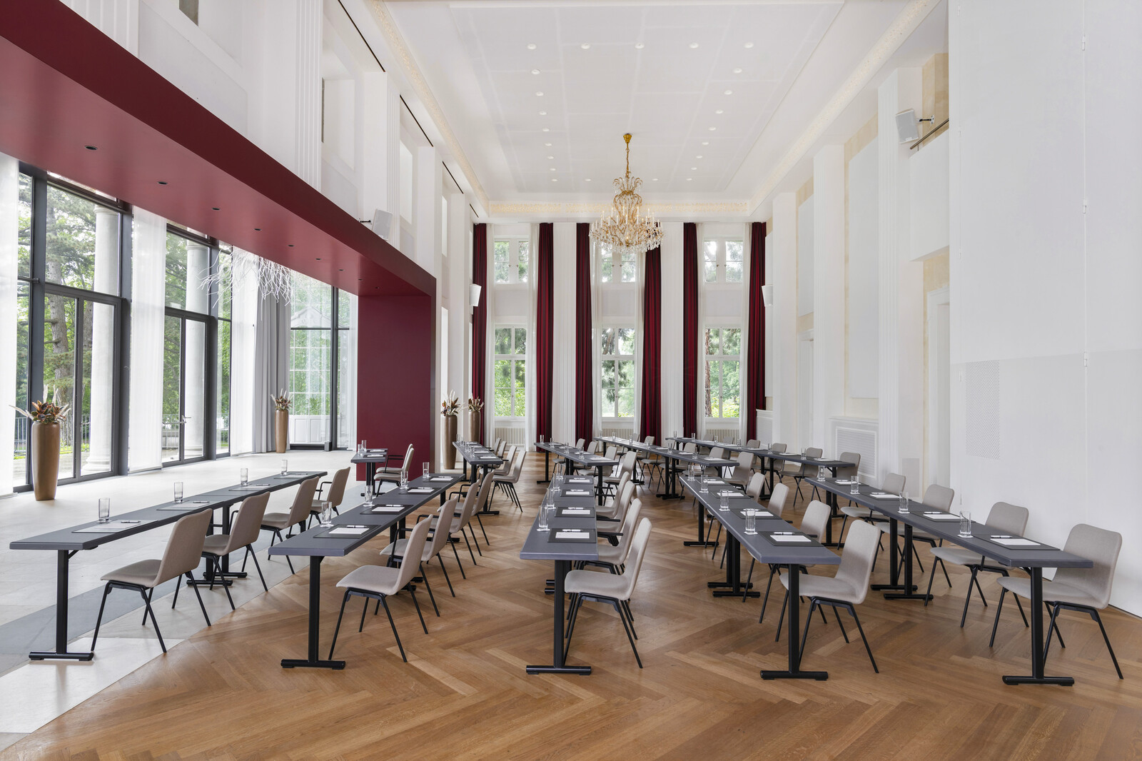 Im Bernhard Simon Saal wurden Stühle aufgestuhlt und vorne eine Bühne mit Leinwand platziert. Ein Kronleuchter hängt von der Decke und rote Vorhänge befinden sich an den Fenstern. Der Kursaal gehört zum Hotel Grand Resort Bad Ragaz, einem Superior Luxushotel in der Schweiz.