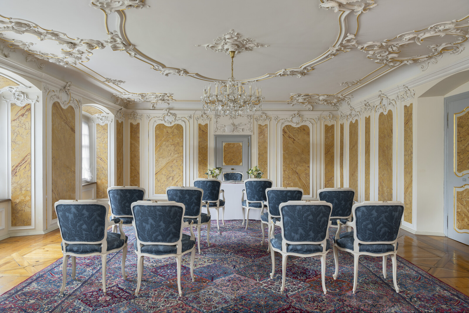 Eine Theaterbestuhlung im offenen Musiksalon mit viel Lichtzugang von aussen und schönem Kronleuchter