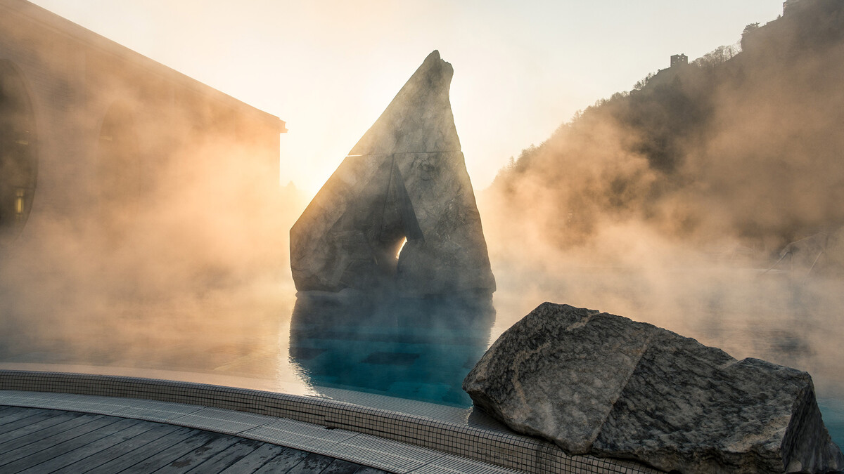 Stein im Aussenpool von der Tamina Therme in leichten Nebel gehüllt