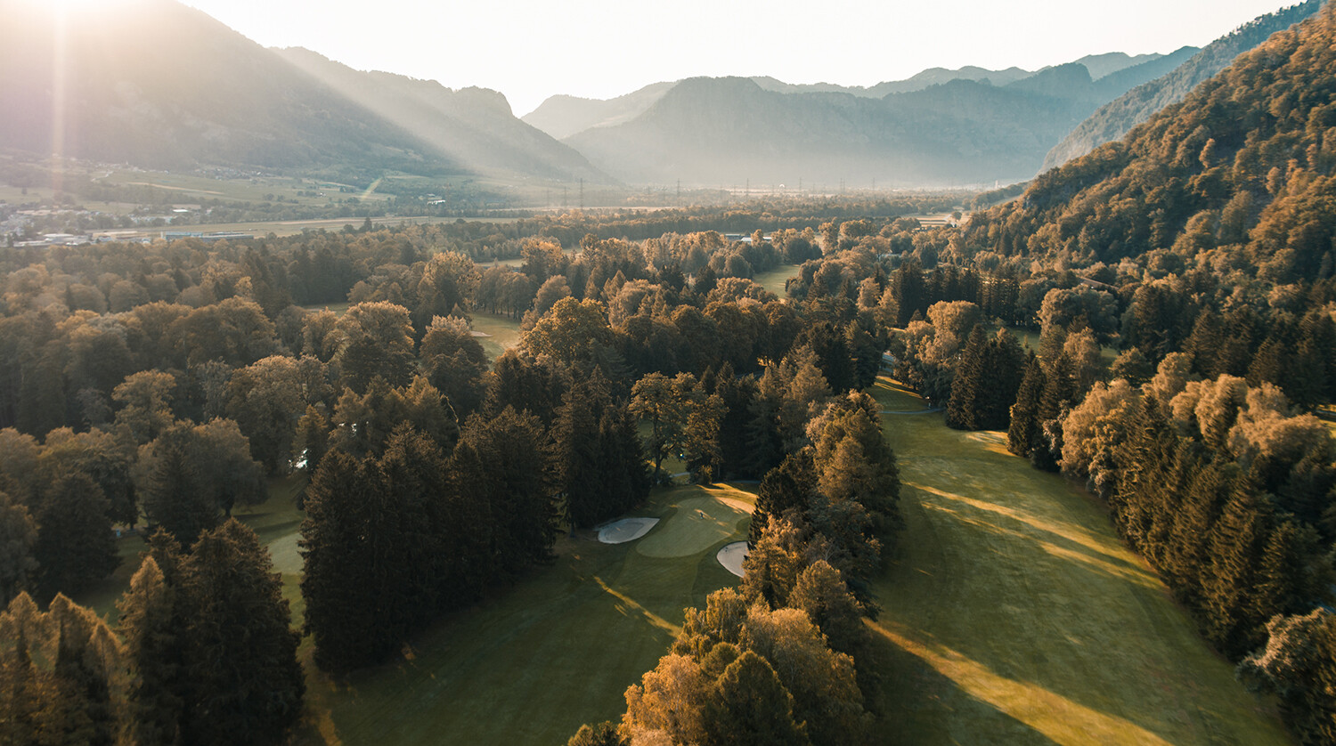 Blick auf den Golfplatz am Fuße einer Bergkette