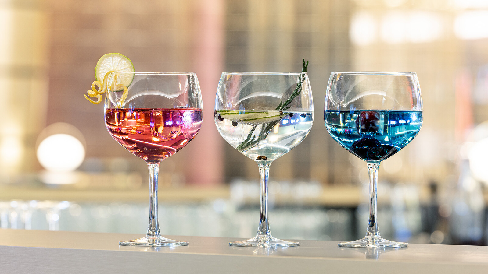 Drei Drinks der Golden Wave Bar des Casino Bad Ragaz. Einer ist rosa mit Zitrone, einer klar mit Rosmarin und der letzte blau mit Beeren.