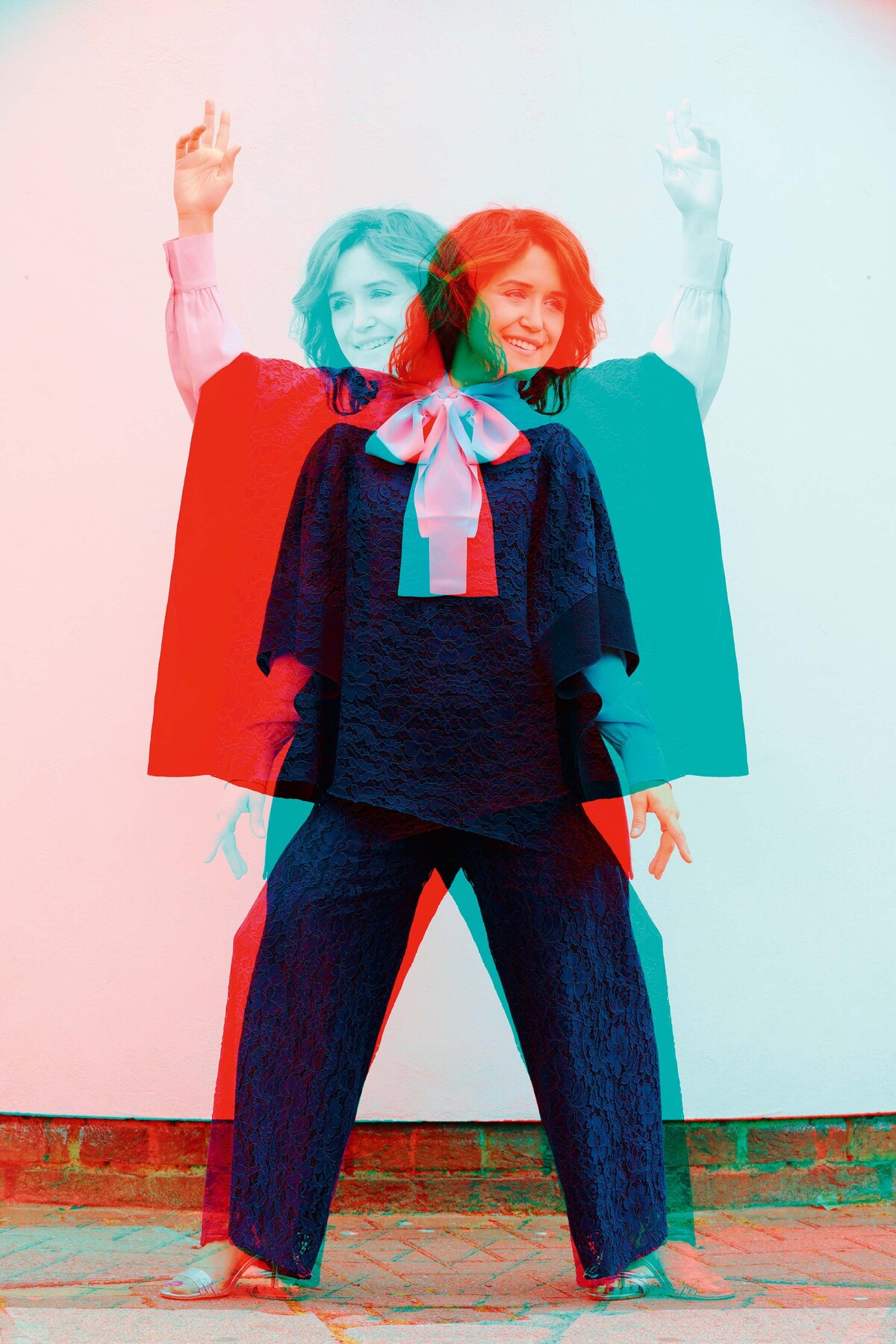 Eine junge Dame wird in diesem Bild gespiegelt. Eine ihrer Versionen ist rot, die andere türkis. Sie steht frontal zum Betrachter und trägt einen luftigen Leinen-Hosenanzug.