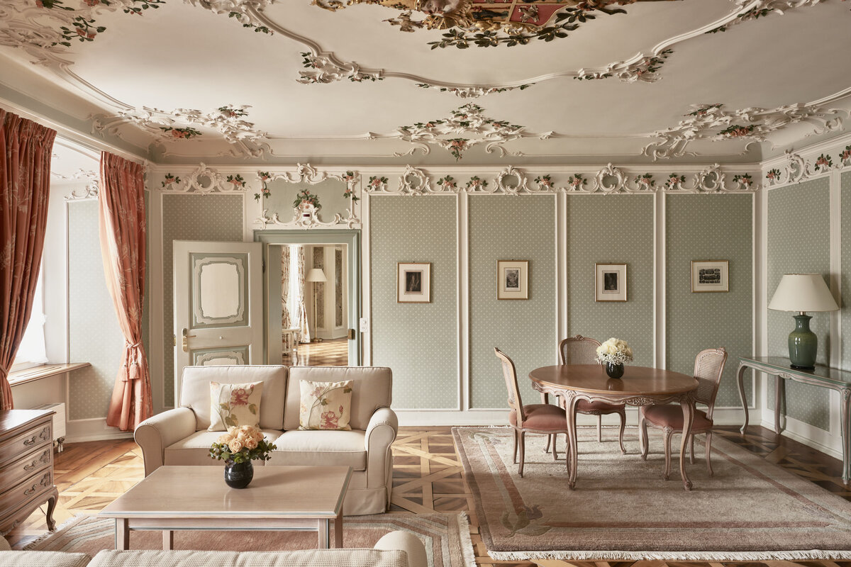 Die elegante Fürstensuite im Hotel Palais Bad Ragaz, mit verschnörkelten Deckenleisten, zartgrünen Wänden und Vintage-Möbeln.